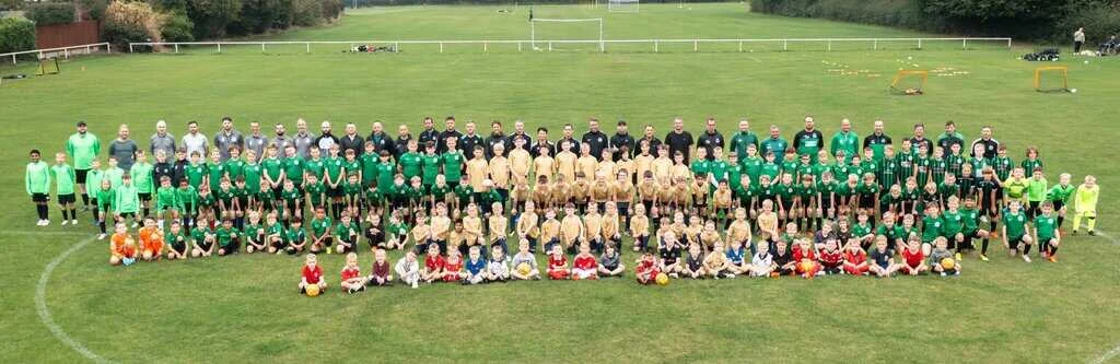 Nova United players and coaches lined up across the pitch at Shuker Fields