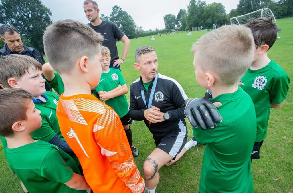 A Nova United coach giving a team talk to young players